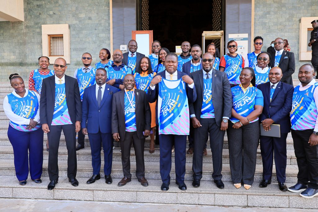 Speaker Oboth poses with for a photo with the organisers of the Cancer run at the step sof Parliament