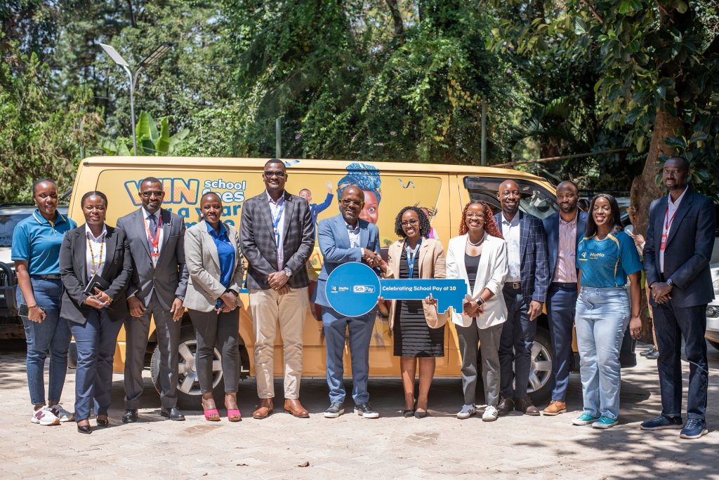 The MTN MoMo Team, led by Phrase Lubega (6L) handed over a Van to the Fincom Technologies' CEO, Charity Atukwatsa Mutagamba (6R) team to mark 10 years of partnership