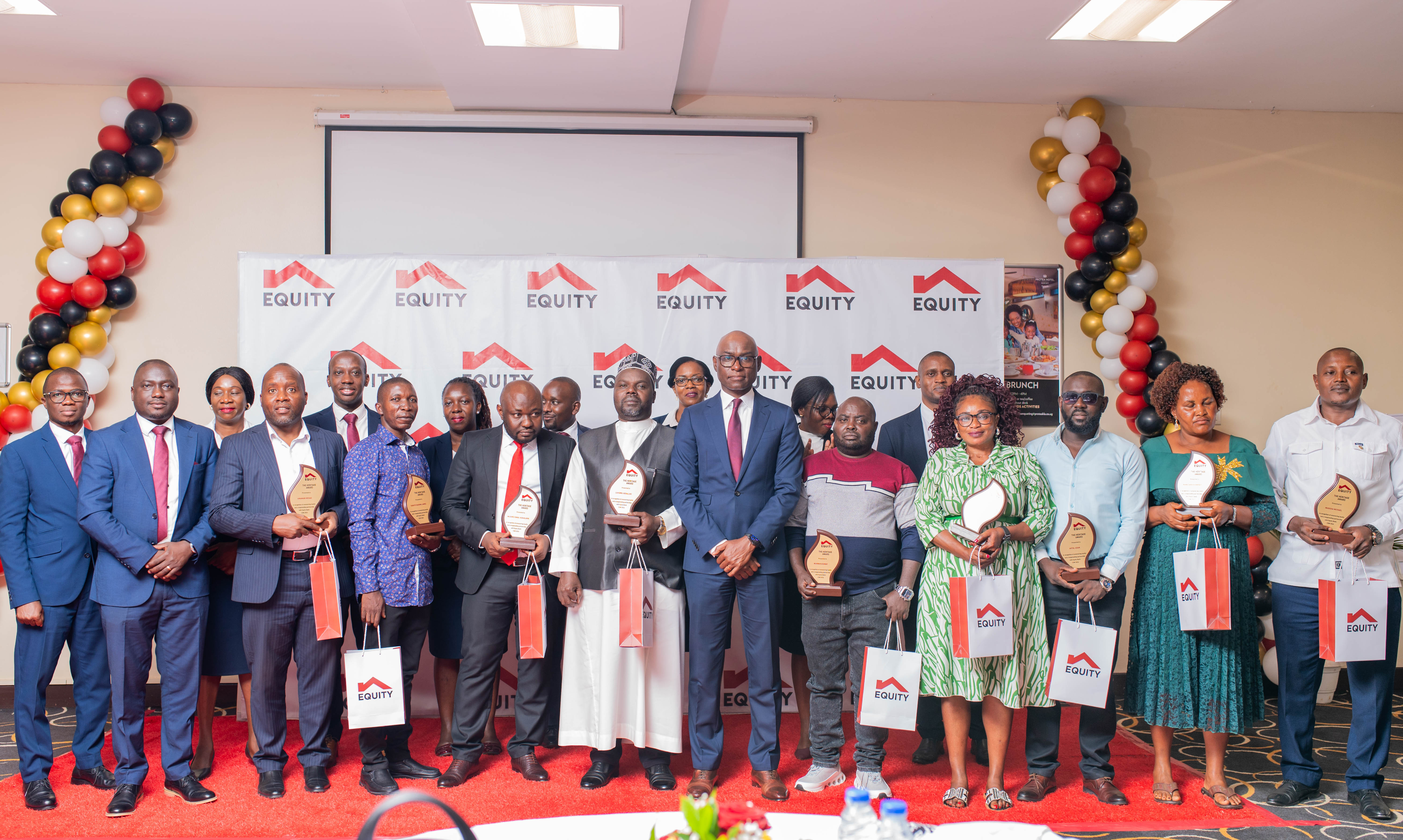 Equity Executive Director Claver Serumaga in the Middle(Red Tie-Blue Suit) with outstanding customers at the Banks Customer Appreacution Breakfast at Protea Hotel